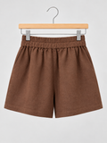 Brown linen-blend shorts with an elastic waistband and side pockets, displayed on a wooden hanger against a light grey background.